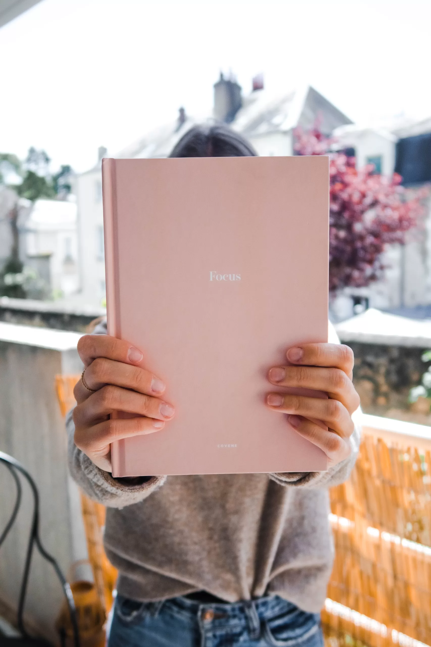 Pink-book-with-the-word-focus-held-by-a-woman-to-get-a-positive-mindset